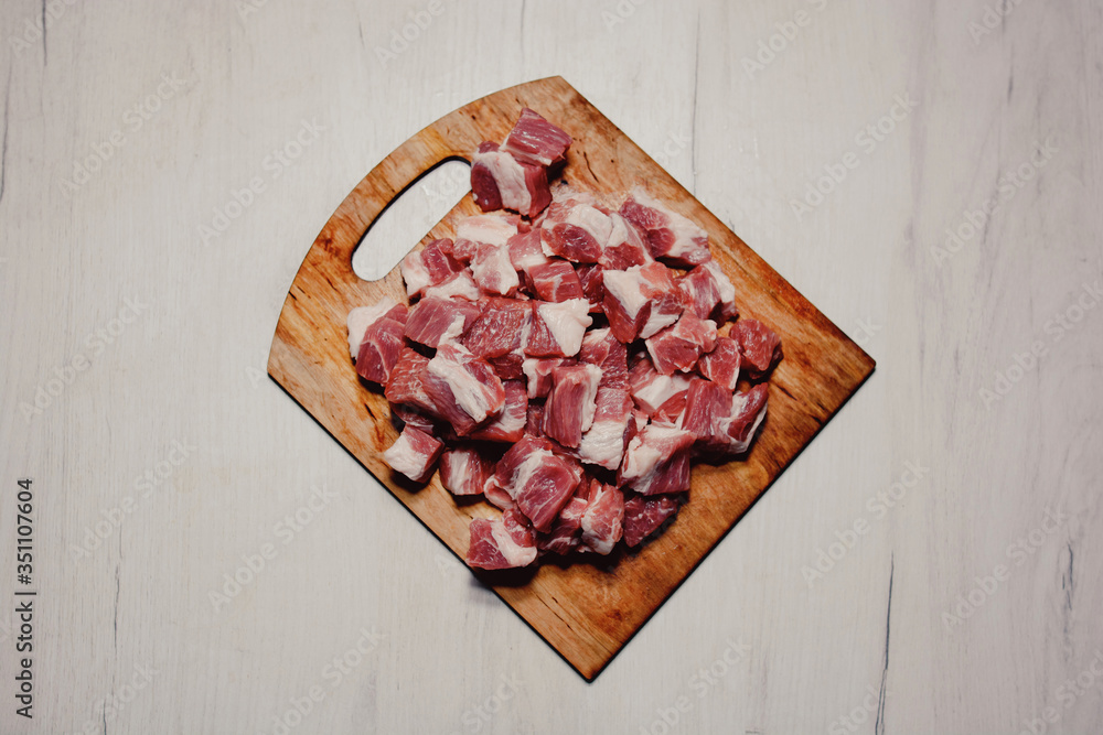 red meat with lard cut into pieces on a cutting wooden board top view red meat with lard cut into pieces on a cutting wooden board top view