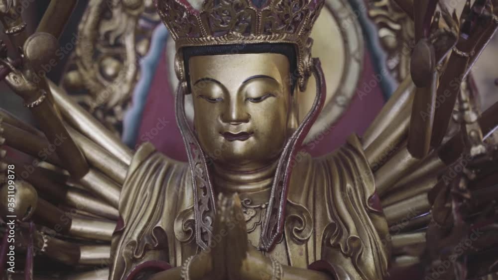A golden Hindu prince statue. The camera focuses on the details. A golden Hindu prince statue. The camera focuses on the details.