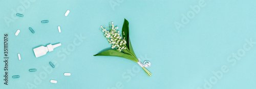 Сoncept of seasonal spring and summer allergies to flowering. Antihistaminic preparations against scented flowers flowers on blue background. Creative banner with copy space. photo