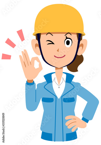 OKのサインを出すヘルメットを被った青い作業着の女性
