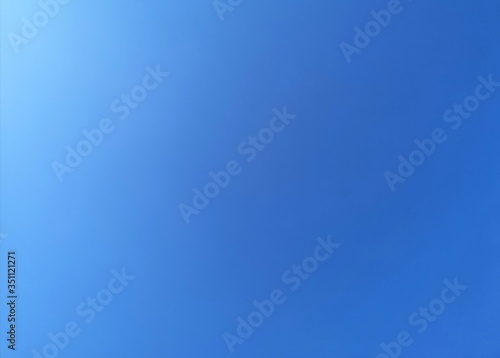 blue sky background with white flare on the sky. Blue color gradian background.