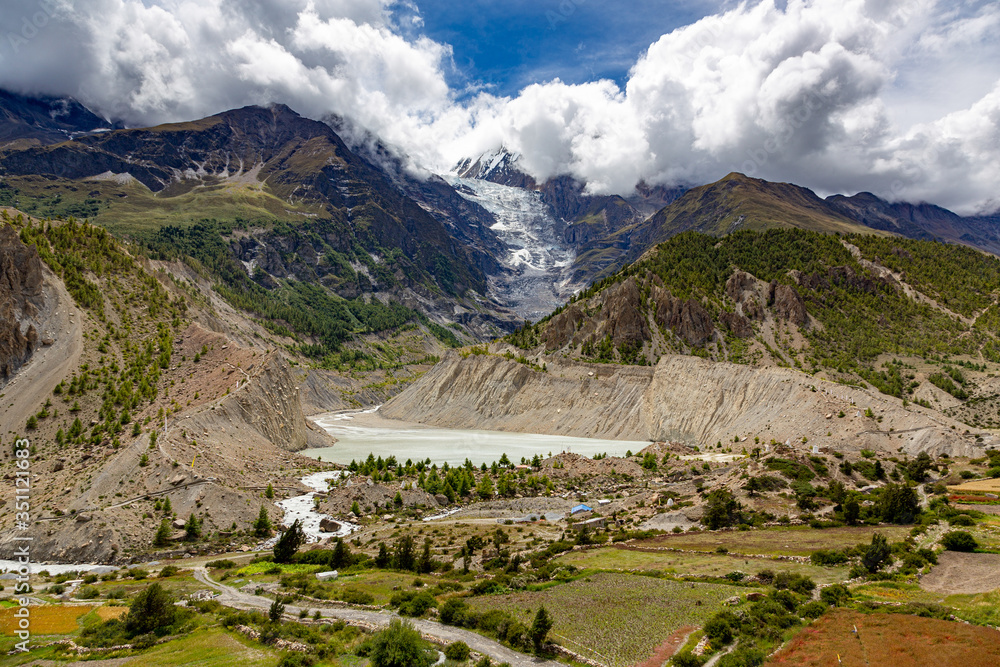 Melting glacier view in Annapurna mountain range with a river and fields
