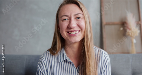 Obraz na plátně Portrait of happy cheerful 30-35 year old smiling blonde Caucasian woman talking looking at camera