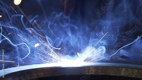 Modern Industrial Robot welding machine active in factory. Automation welding mechanical procedure. Metal iron laser argon welding robot in factory. Automation of work. Slow motion