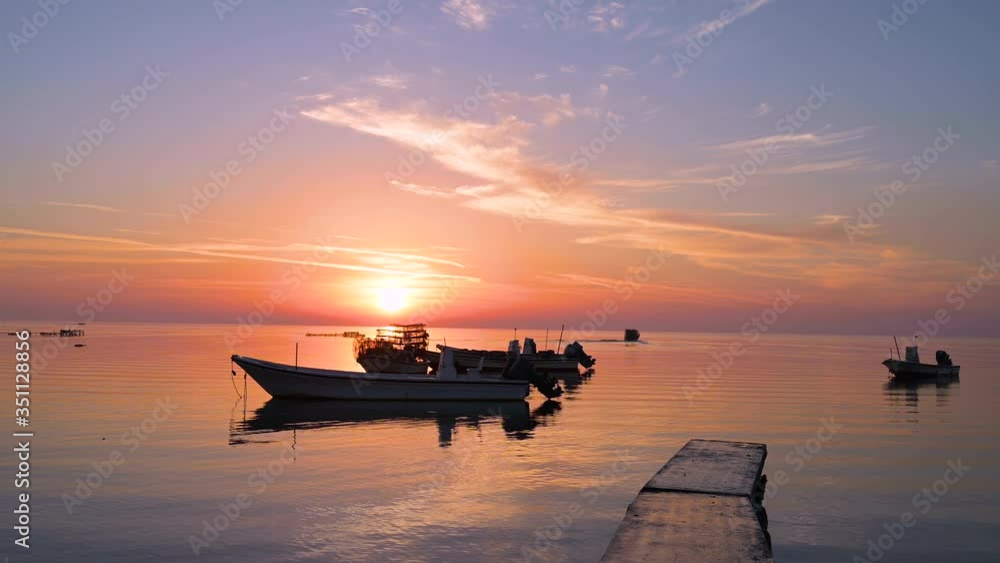 Beautiful colorful calm sea water at pier, and fisherman boats floating over twilight sunrise clouds sky background, Bahrain. Beautiful colorful calm sea water at pier, and fisherman boats floating over twilight sunrise clouds sky background, Bahrain.
