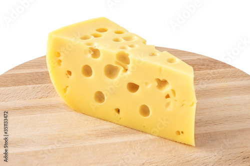 piece of cheese on a wooden board, triangular cheese piece close up