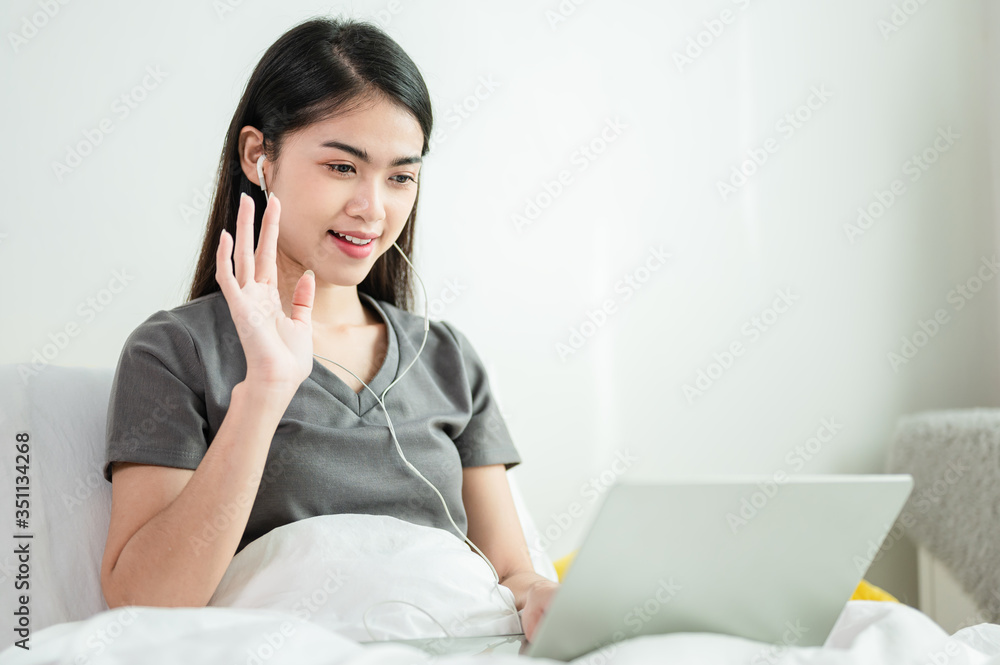 Beautiful Asian woman are video calling with someone by laptop for work from home or social distancing in self quarantine policy. New normal, teleconference, online communication concept. Beautiful Asian woman are video calling with someone by laptop for work from home or social distancing in self quarantine policy. New normal, teleconference, online communication concept.