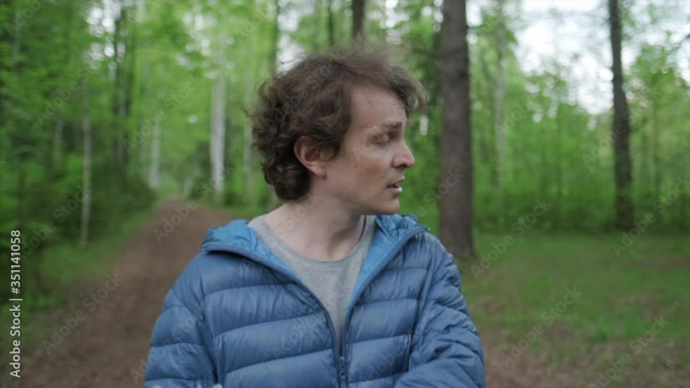 Breathing without mask. Young man stands in the park, takes off the protective mask and starts breathing fresh air deeply Breathing without mask. Young man stands in the park, takes off the protective mask and starts breathing fresh air deeply