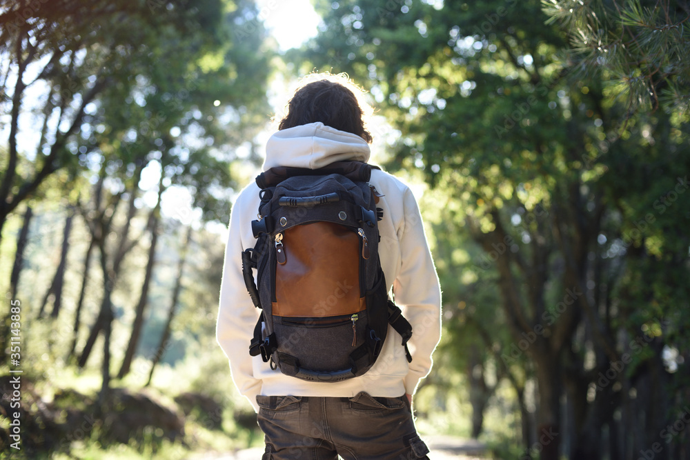 Man on his back with travel backpack at sunrise in the forest.. Man on his back with travel backpack at sunrise in the forest..