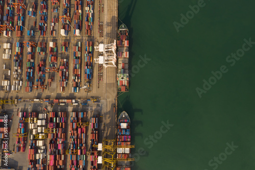 Container ship in export and import business and logistics. Shipping cargo to harbor by crane. Water transport International. Aerial view in the evening