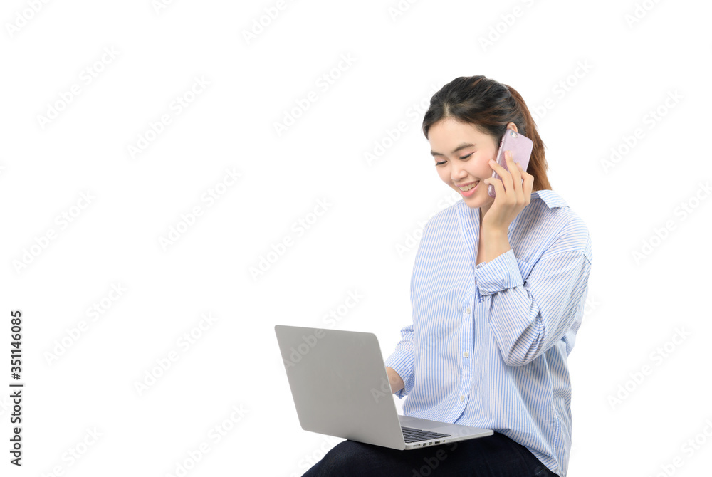 Woman working on laptop while talking on phone, warm light Woman working on laptop while talking on phone, warm light