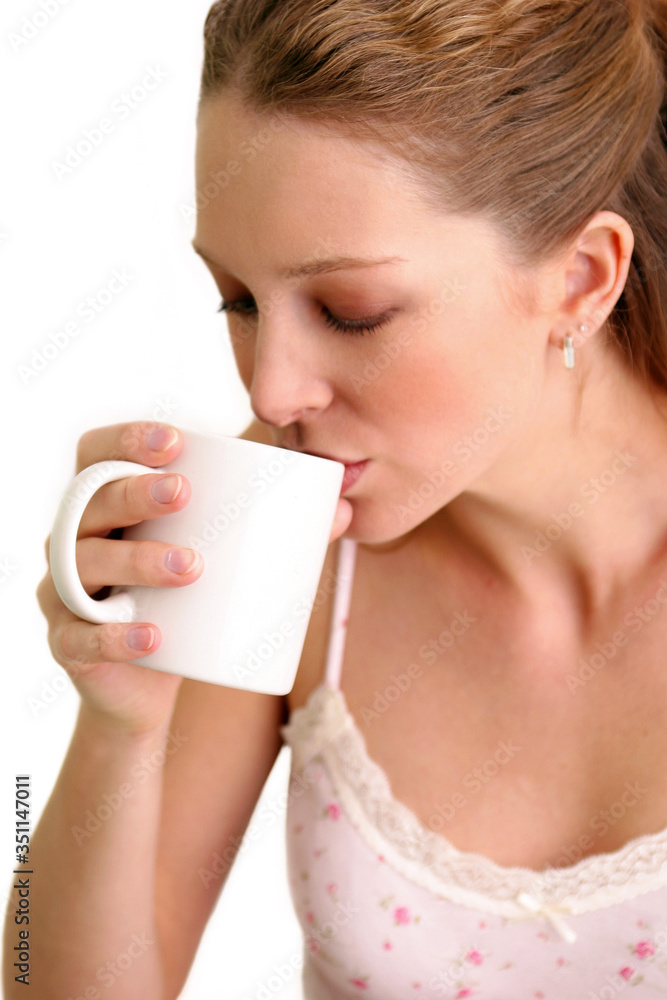A woman drinking from a white cup A woman drinking from a white cup