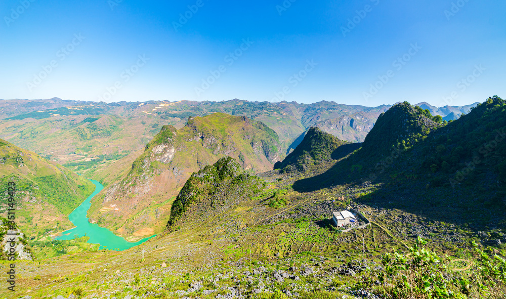 Fototapeta premium Ha Giang karst geopark mountain landscape in North Vietnam. Winding road in stunning scenery. Ha Giang motorbike loop, famous travel destination bikers easy riders.