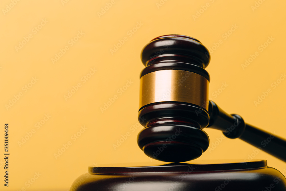 Judge Gavel on a wooden table and yellow-orange background. Judge Gavel on a wooden table and yellow-orange background.