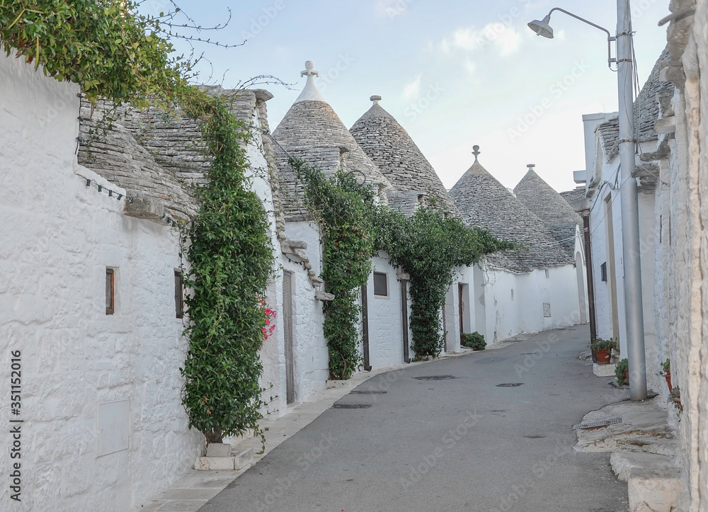 ALBEROBELLO, ITALY, EUROPE, AUTUMN 2019. Beautiful street of white trulli houses with a cone-shaped roof in the small town of southern Italy.