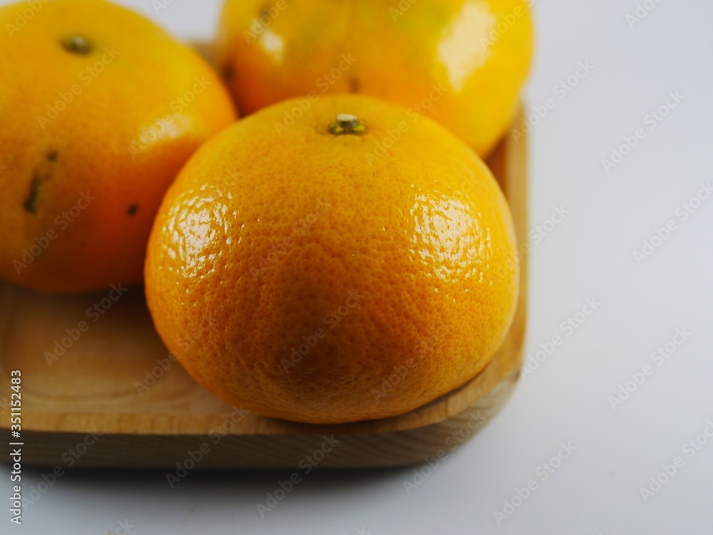 three orange on wooden plate in white background three orange on wooden plate in white background