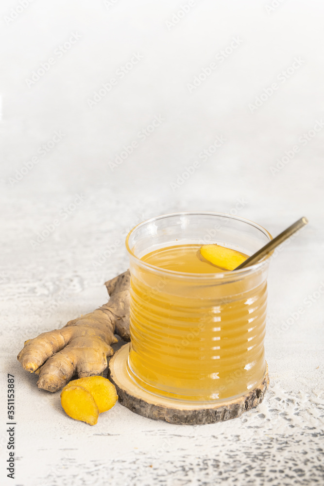 Ginger tea with honey and lemon in glass. Warm revitalizing beverage used to help relieve cold and flu symptoms. Ginger tea with honey and lemon in glass. Warm revitalizing beverage used to help relieve cold and flu symptoms.
