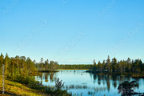 Beautiful landscape with water of calm lake or swamp in a autumn or summer evening. Concept of a walk, rest and travel on nature. Nature in Finland or Karelia in Russia