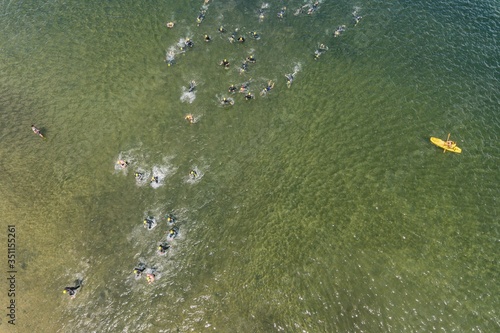 Triathlon swimming contest in lake swimmers competition aerial drone photo
