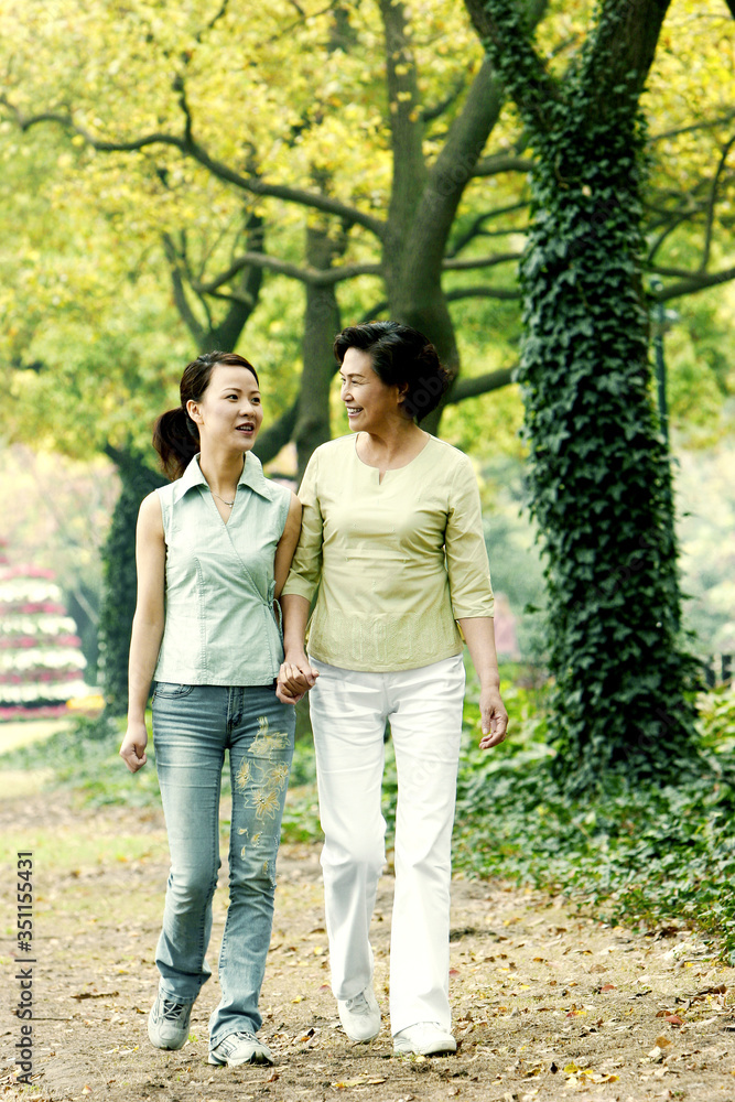 Mother and daughter walking in the park