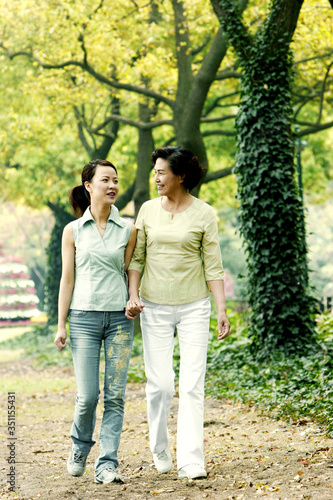 Mother and daughter walking in the park © ImageHit