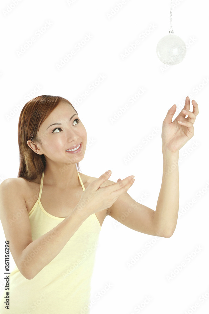 Woman looking at hanging Christmas ornament Woman looking at hanging Christmas ornament