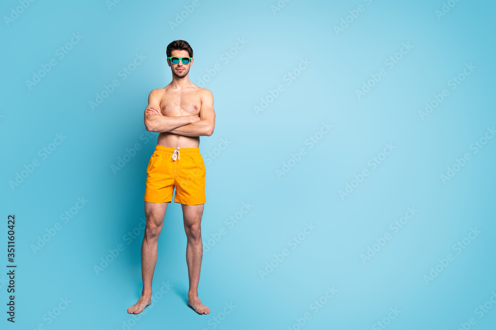 Full length body size view of his he nice attractive virile masculine guy wearing swimming shorts crossed hands isolated over bright vivid shine vibrant green blue turquoise color background