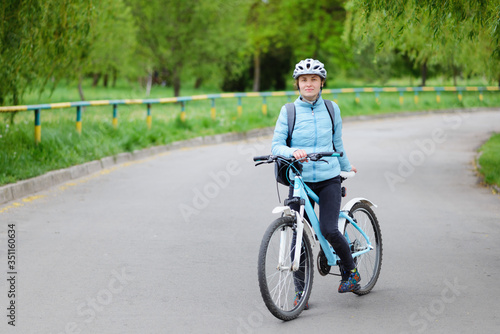 Beautiful woman standing with a bicycle on the road