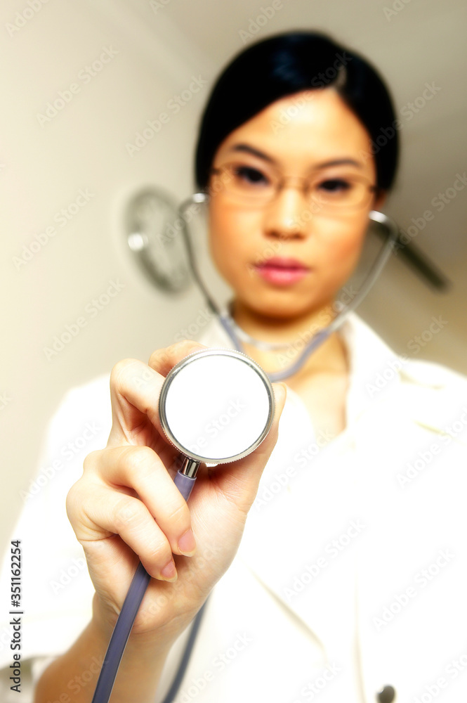 Female doctor placing her stethoscope near to the camera Female doctor placing her stethoscope near to the camera