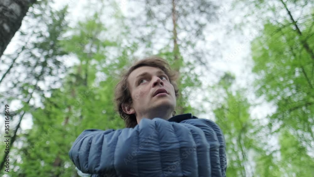 Breathing without mask. Young man stands in the park, takes off the protective mask and starts breathing fresh air deeply Breathing without mask. Young man stands in the park, takes off the protective mask and starts breathing fresh air deeply