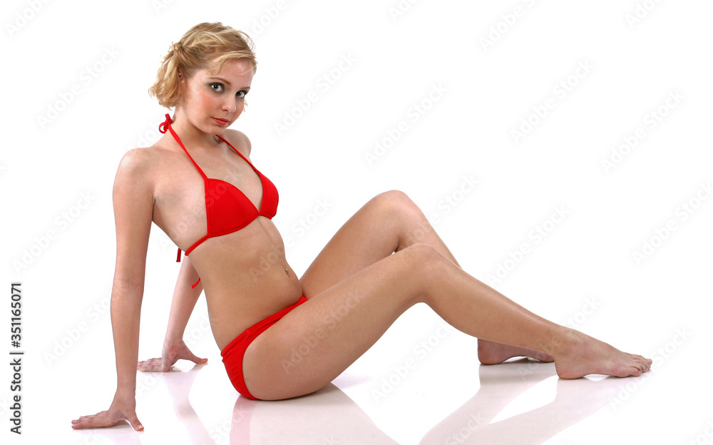 Studio shot of woman in red bikini posing on the floor Studio shot of woman in red bikini posing on the floor