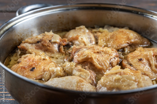 Appetizing tasty fried chicken thighs in a pan, close-up, shallow depth of field, selective focus. Homemade food concept.