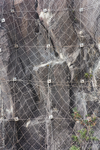 Εκτύπωση καμβά Slope of the mountain with a rockfall protection net preventing rocks falling on