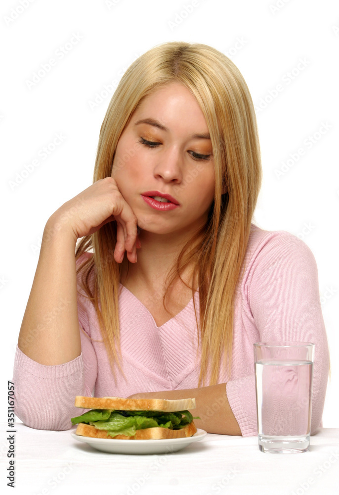 Woman having no appetite in eating a vegetarian sandwich Woman having no appetite in eating a vegetarian sandwich