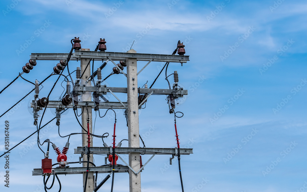 Three-phase electric power for transfer power by electrical grids. Electric power for support manufacturing industry. High voltage electric poles and wire lines against blue sky and white clouds. Three-phase electric power for transfer power by electrical grids. Electric power for support manufacturing industry. High voltage electric poles and wire lines against blue sky and white clouds.