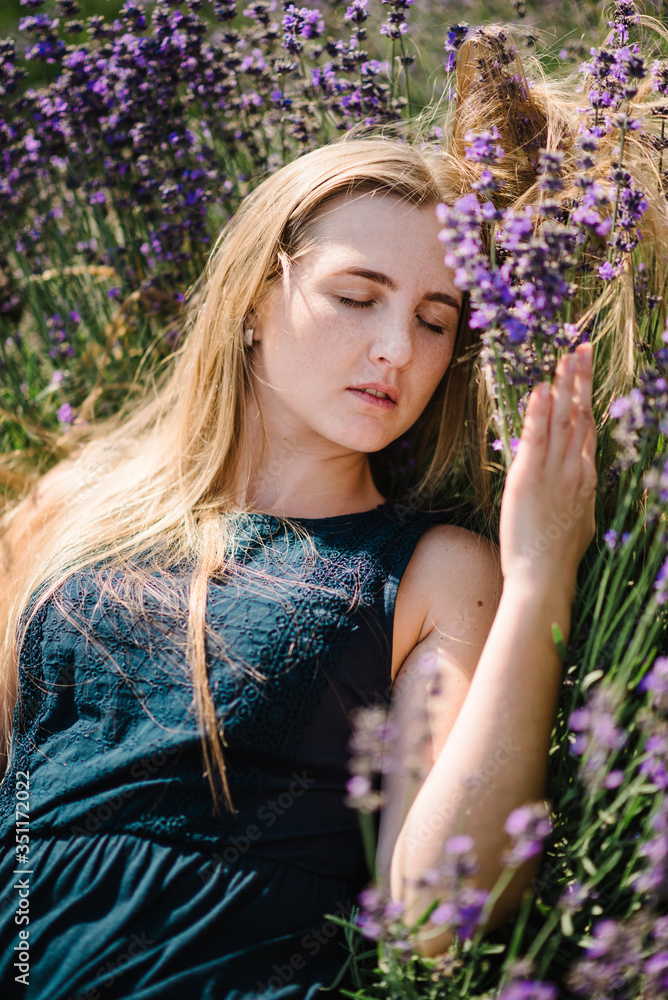 Beautiful girl in dress lying down on purple the lavender field. Beautiful woman in the lavender field on sunset in France. Soft focus. Enjoy on the floral glade, summer nature. Close up. Beautiful girl in dress lying down on purple the lavender field. Beautiful woman in the lavender field on sunset in France. Soft focus. Enjoy on the floral glade, summer nature. Close up.