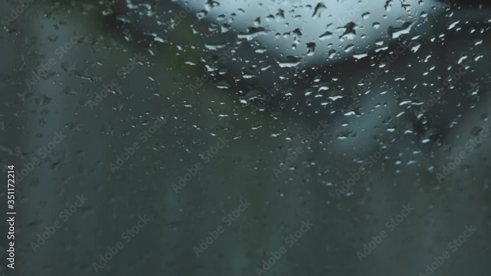 Rain Drops In Front Of A Wind Shield Of A Car On A Rainy Day. - close up shot Rain Drops In Front Of A Wind Shield Of A Car On A Rainy Day. - close up shot