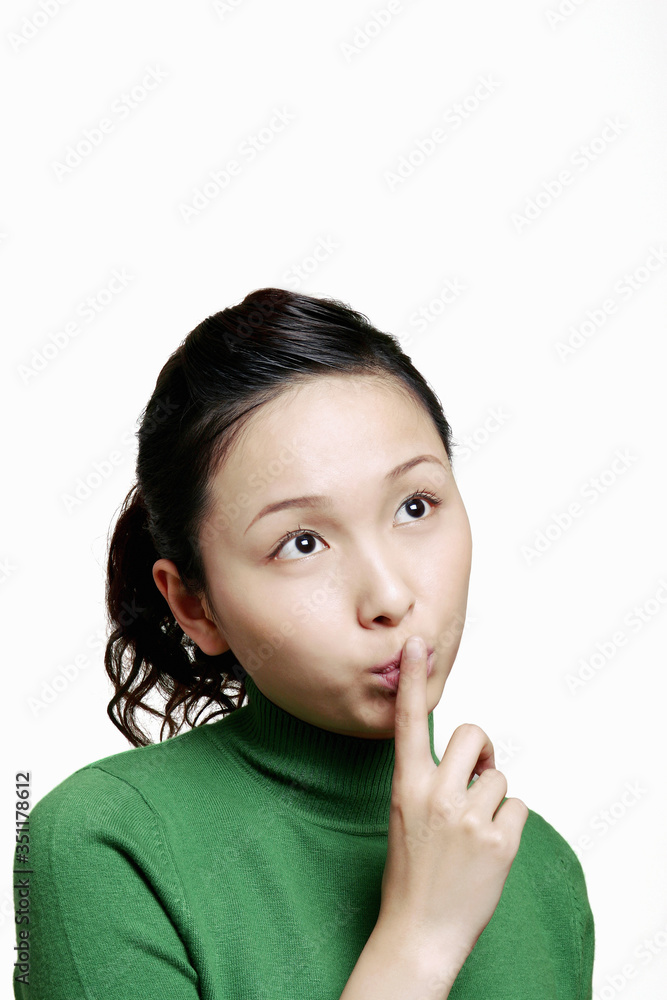 Woman showing hushing sign.