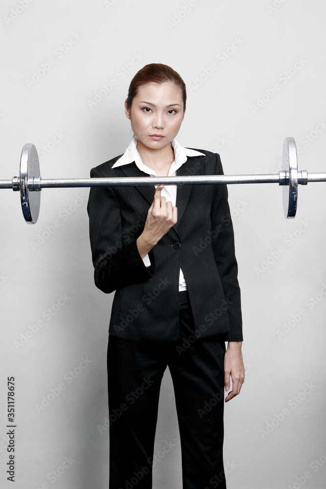 Woman lifting bar bell with fingers.
