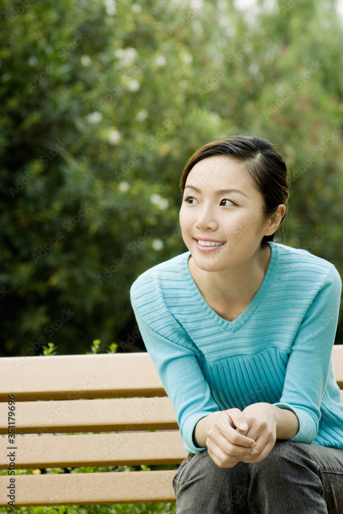 Woman sitting on the bench smiling. Woman sitting on the bench smiling.