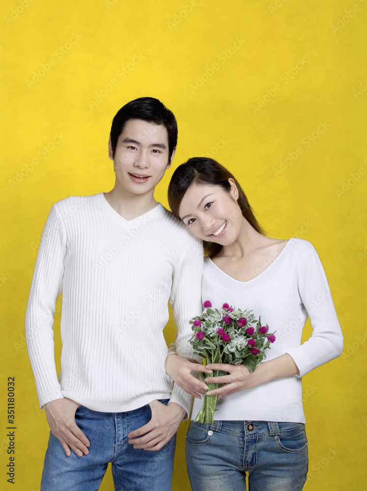 Woman holding a bouquet of flowers and leaning on her boyfriend's shoulder. Woman holding a bouquet of flowers and leaning on her boyfriend's shoulder.