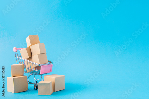Picture of shopping cart carrying large big parcels import export sales management factory distribution production holiday black Friday isolated over bright vivid shine vibrant blue color background
