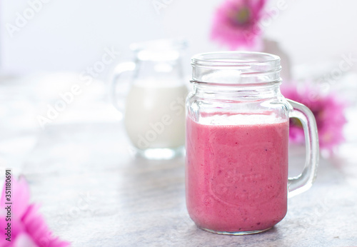 Beautiful light fruit smoothie in the glass with white and pink colors. Berries drink. Milk natural organic products