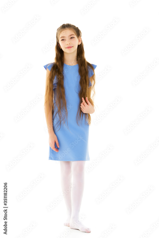 A little girl fixes her hair.The concept of beauty and fashion