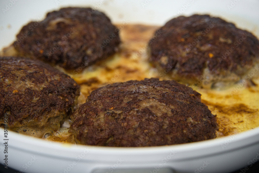 Frikadellen Gemüse Fleisch Paddys mit Kurkuma beim Anbraten in weißer Teflonpfanne mit Kokosöl, Produktbild Frikadellen Gemüse Fleisch Paddys mit Kurkuma beim Anbraten in weißer Teflonpfanne mit Kokosöl, Produktbild