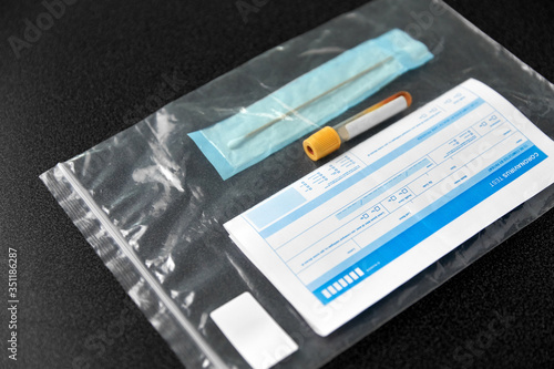 medicine, healthcare and pandemic concept - beaker with test, cotton swab and medical report in plastic zipper bag