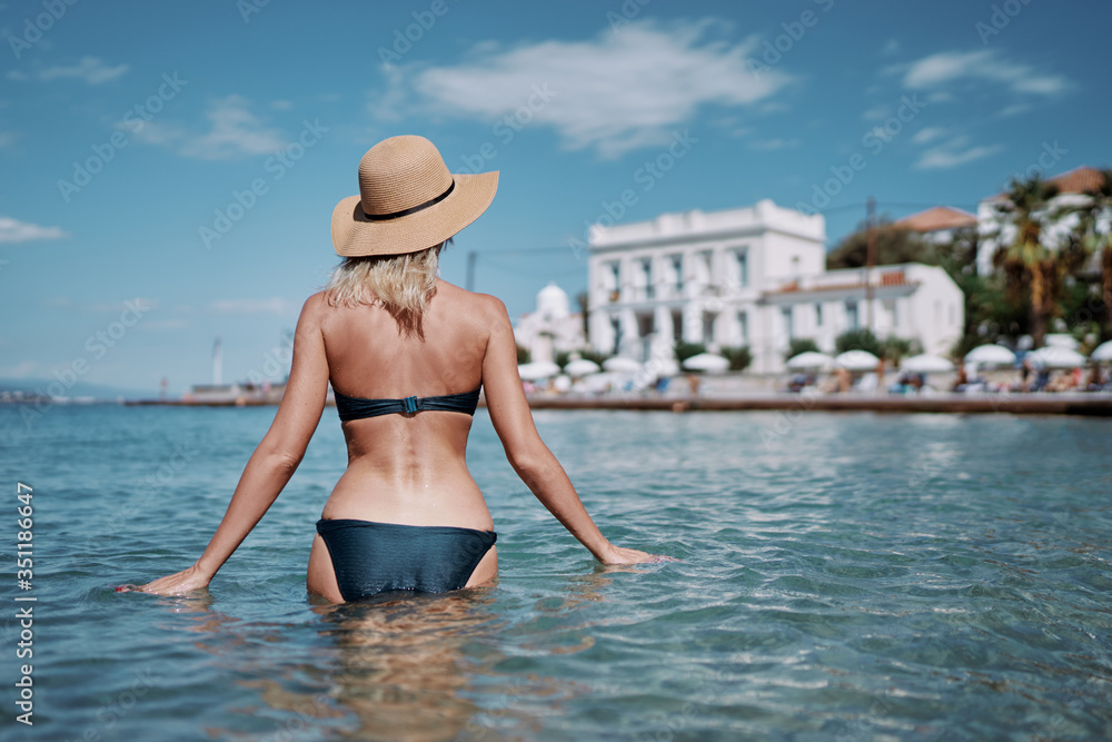 Vacation on the seashore. Back view of young woman enjoying the view of the Spetses Island, Greece. Vacation on the seashore. Back view of young woman enjoying the view of the Spetses Island, Greece.