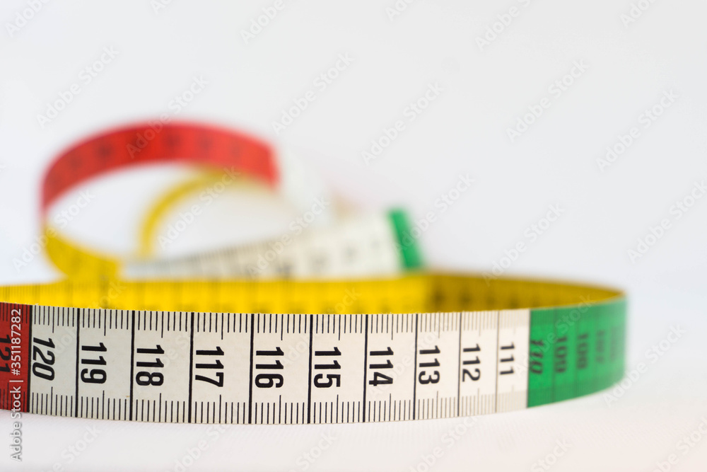 Detail of a colorful measuring tape isolated on white. Diet and measure concept. Detail of a colorful measuring tape isolated on white. Diet and measure concept.