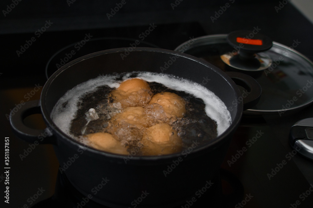 Fünf Bio Frühstückseier, Hühnereier kochen im Wasserbad Fünf Bio Frühstückseier, Hühnereier kochen im Wasserbad