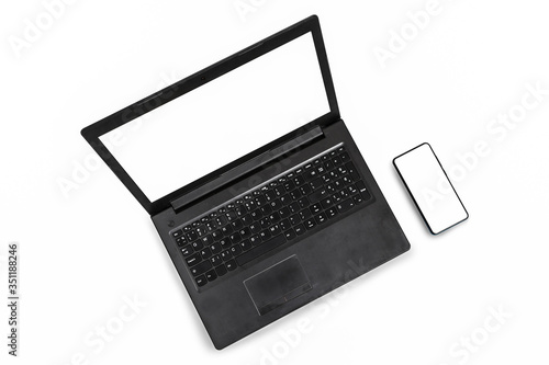 Laptop and smartphone with blank screen isolated on white background, clipping path. Copy space. Top view.